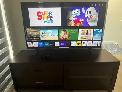 a flat screen tv sitting on top of a dresser at Cozy house with 4 Bedrooms 3 Full bath and 1 half bath in Calgary