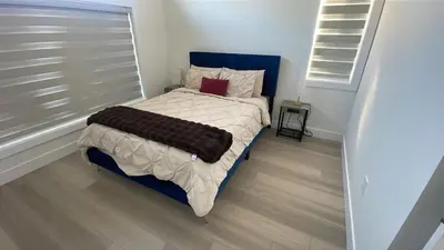 a small bedroom with a bed with a blue headboard at Luxury Home in Victoria