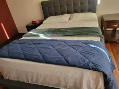 a bed with a blue blanket on top of it at A Gorgeous Mansion for Jasper Vacation in Hinton