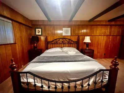 a bedroom with a large bed with wooden walls at Luxury Space close to UBC in Vancouver