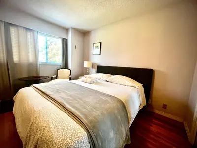 a bedroom with a large bed and a window at Luxury Space close to UBC in Vancouver