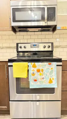 a stove with a microwave on top of it at Red Deer Stay- 2BR Private Suite in Red Deer