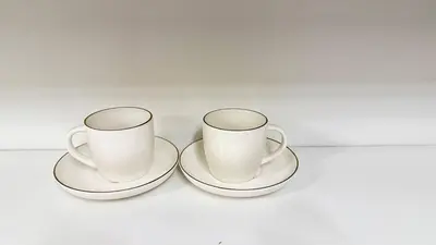 two white coffee cups and saucers on a table at Red Deer Stay- 2BR Private Suite in Red Deer