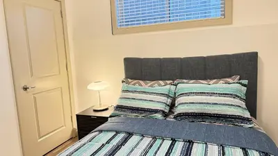 a bedroom with a bed with two pillows on it at Red Deer Stay- 2BR Private Suite in Red Deer
