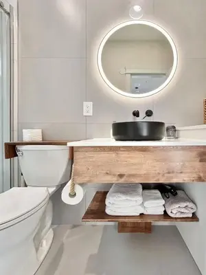 a bathroom with a sink and a toilet and a mirror at Vancouver Mini Suite in Vancouver