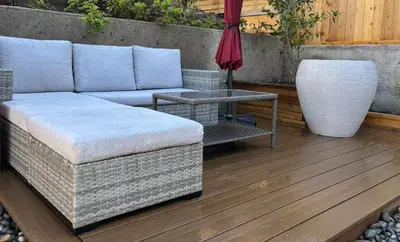 a couch and a table and a vase on a deck at Vancouver Mini Suite in Vancouver