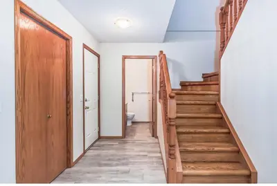 a hallway with a wooden stairway leading to a bathroom at Master Bedroom with attached bathroom in Airdrie