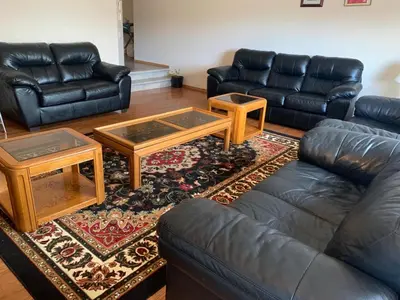 a living room with couches and tables on a rug at Master Bedroom with attached bathroom in Airdrie