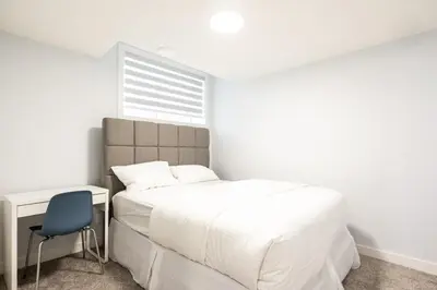 a bedroom with a bed and a desk and a chair at Olympia Lodge 2 room Apartment in Calgary
