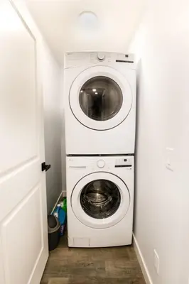 a washer and dryer in a small room at Olympia Lodge 2 room Apartment in Calgary