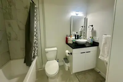 a bathroom with a white toilet and a sink at Cozy 2BR Retreat - 10 Mins to WEM - Free Parking & WiFi in Edmonton