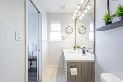 a bathroom with a sink and a mirror at Soothing Minimalist Escape - Suite with Balcony & Fireplace in Vancouver
