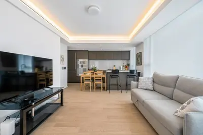 a living room with a couch and a kitchen at Urban Retreat 2BR Condo with Stunning City View in Vancouver