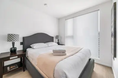a bedroom with a large bed and a large window at Urban Retreat 2BR Condo with Stunning City View in Vancouver