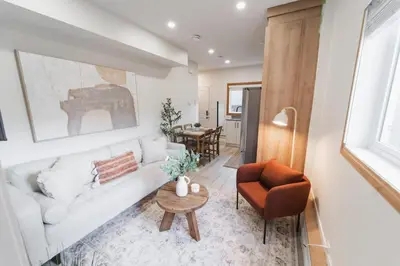 a living room with a white couch and a chair at Chic Garden Suite Hideaway 2Bedroom Games Room in Edmonton
