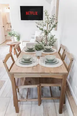 a wooden table with chairs and plates on it at Chic Garden Suite Hideaway 2Bedroom Games Room in Edmonton