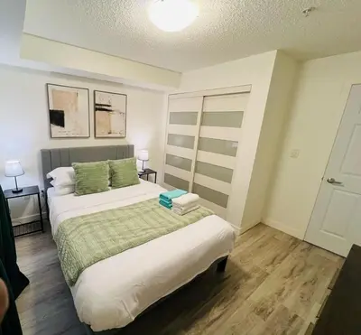 a bedroom with a large bed with green pillows at Mordern 2BedRoom Downtown Apt with Free Parking & Wifi in Edmonton
