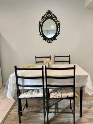 a dining room table with two chairs and a mirror at Holiday Home in Coquitlam