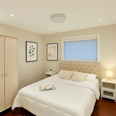 a bedroom with a large white bed and a window at The Cozy Quad In the Heart of Vancouver in Vancouver