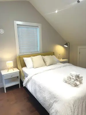 a bedroom with a white bed and a window at The Cozy Quad In the Heart of Vancouver in Vancouver