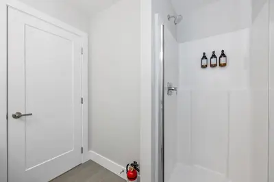 a hallway with two white doors and a red object at Cozy Langford suite in Langford