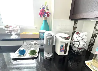 a kitchen counter with a coffee maker on it at European-American Style Suite in Coquitlam