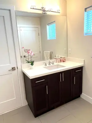 a bathroom with a sink and a mirror at European-American Style Suite in Coquitlam