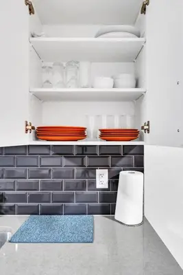 a kitchen with a blue and white tiled wall at Private, Stylish and Peaceful 2BR Guest Suite in Calgary
