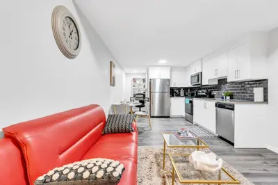 a living room with a red couch and a kitchen at Private, Stylish and Peaceful 2BR Guest Suite in Calgary
