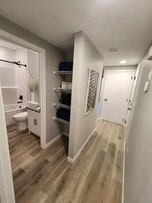 a hallway with a bathroom with a toilet and a sink at Brand New Modern 2 Bedroom Basement Suite in Calgary