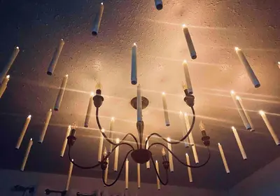 a chandelier with lit candles hanging from a ceiling at Magical Themed Decor! Pets Welcome! 3 Bedrooms in Chase