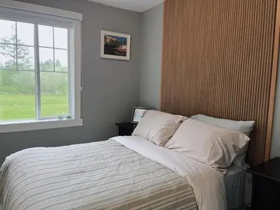 a bedroom with a large bed with a window at Sunshine garden 3 bedrooms2 bathrooms1 living room1 kitchen in Aldergrove