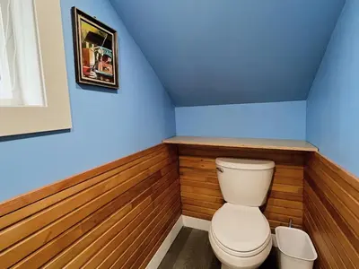 a bathroom with a toilet in a room with blue walls at Sunshine garden 3 bedrooms2 bathrooms1 living room1 kitchen in Aldergrove