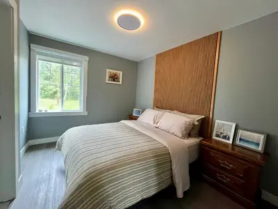 a bedroom with a large bed and a window at Sunshine garden 3 bedrooms2 bathrooms1 living room1 kitchen in Aldergrove