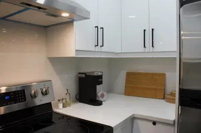 a kitchen with white cabinets and a coffee maker on the counter at Modern 2 Beds 1 Bath Private Suite, Close to mountains in Calgary