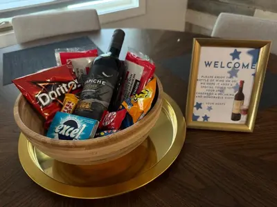 a basket of snacks and a bottle of wine on a table at Luxurious Air Conditioned Inner City Bungalow in Calgary