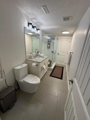 a bathroom with a toilet and a sink and a shower at Luxurious Air Conditioned Inner City Bungalow in Calgary