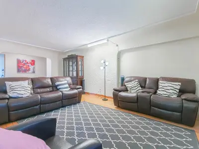 a living room with two leather couches and a rug at Cozy Airb&b Suite in South Vancouver in Vancouver