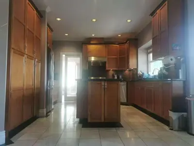 a kitchen with wooden cabinets and a tile floor at Vancouver Richmond Villa39 in Richmond