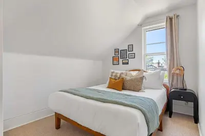 a bedroom with a bed and a window at The Red Steps Away From World's Largest Dinosaur 3BR House in Drumheller