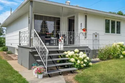 a house with a staircase in front of it at The Coal Stone throw away from Red Deer River 2BR House in Drumheller