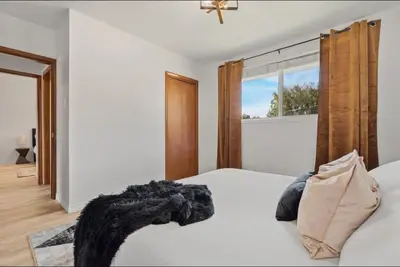 a bedroom with a white bed and a window at The Coal Stone throw away from Red Deer River 2BR House in Drumheller