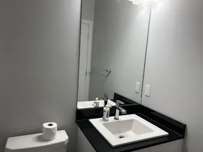 a bathroom with a white sink and a mirror at 1-bedroom private suite, 20 minutes from the airport, with a kitchen in Edmonton