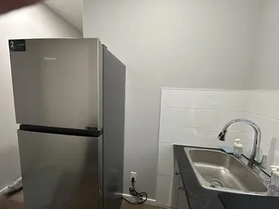 a kitchen with a stainless steel refrigerator next to a sink at 1-bedroom private suite, 20 minutes from the airport, with a kitchen in Edmonton