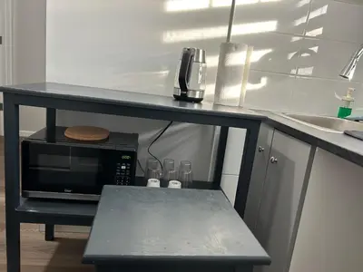 a black counter with a microwave in a kitchen at 1-bedroom private suite, 20 minutes from the airport, with a kitchen in Edmonton