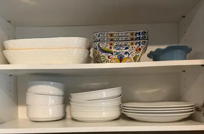 a white shelf with plates and bowls and bowls at Victoria Colwood Place in Colwood