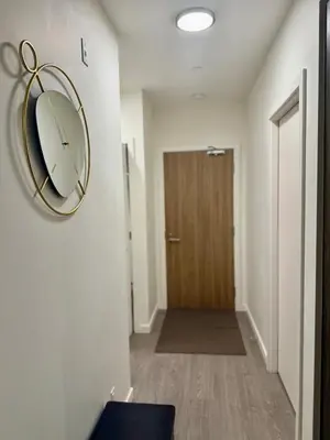 a hallway with a clock on the wall and a door at Victoria Colwood Place in Colwood