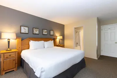 a bedroom with a large white bed and two lamps at The Snowbird by Whiski Jack in Whistler