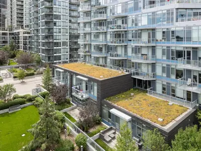 an apartment building with a roof with plants on it at Luxury Waterfront Suite with City Views and AC in Calgary