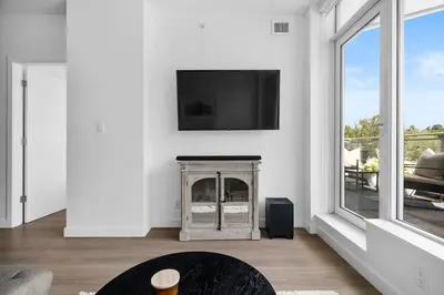 a living room with a fireplace and a tv on a wall at Luxury Waterfront Suite with City Views and AC in Calgary